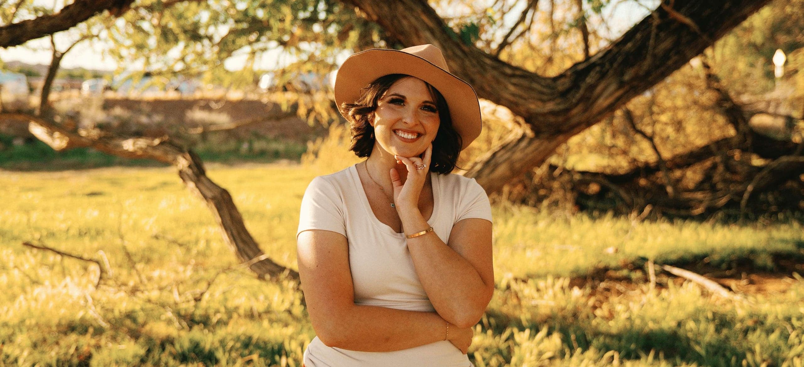 Shelbie Bouck, LCMHC, smiling in a sunlit field