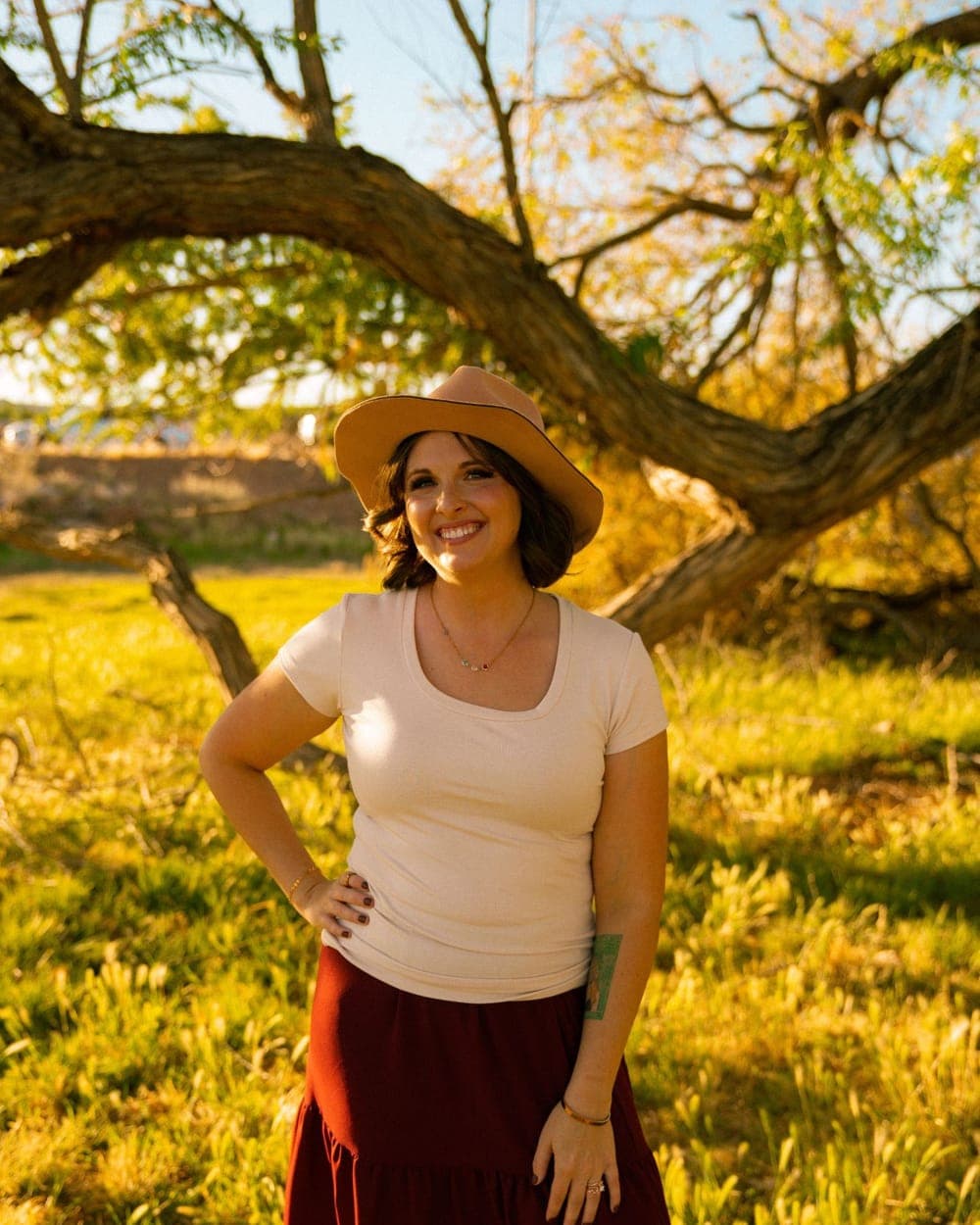 Shelbie Bouck, LCMHC, smiling in a sunlit field
